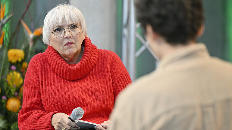 Abgebildet: Staatsministerin für Kultur und Medien Claudia Roth im Gespräch mit Poetry Slammer Benjamin Poliak.