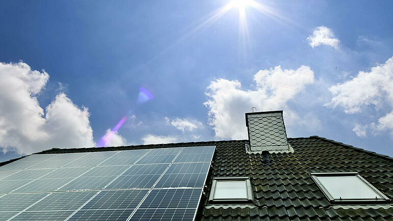 Sonnenkollektoren zur Erzeugung sauberer Energie auf dem Dach eines Wohnhauses im Sonnenlicht