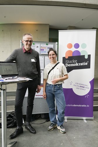 Ein Mann und eine Frau vor dem Stand der Initiative "Starke Demokratie".
