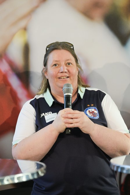 Frau spricht , beide Hände am Mikro