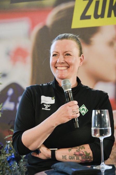 Frau sprich mit Mikro in der Hand