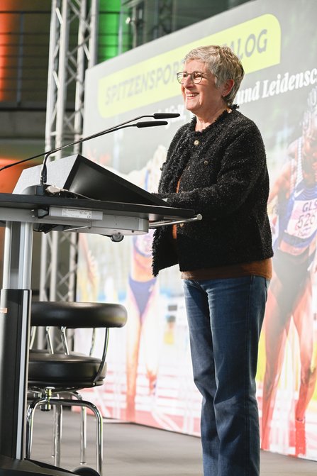 Frau seitlich an einem Redepult