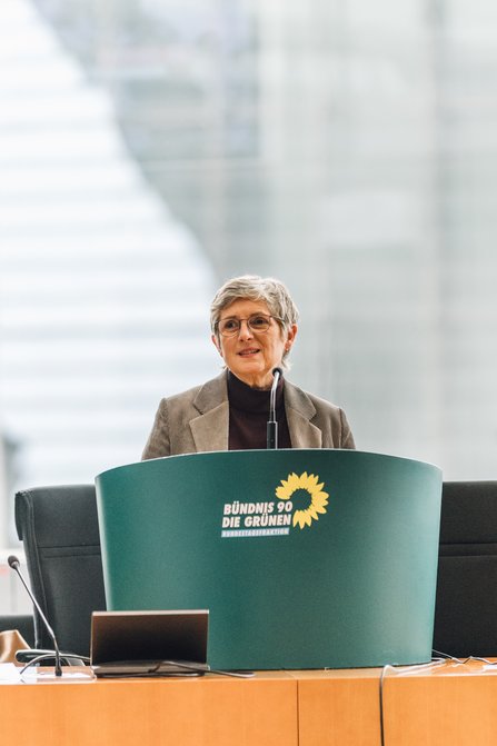 Britta Haßelmann steht an einem grünen Redepult mit dem Logo der Bundestagsfraktion