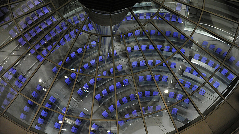 Die Sitze des Bundestags sind im Reichstagsbebäude in Berlin durch die Glaskuppel zu sehen.