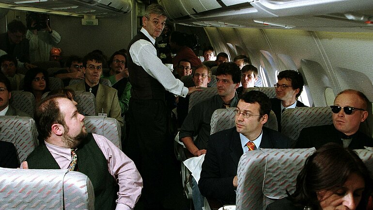 28.10.1998, Joschka Fischer im Airbus A 310 der Flugbereitschaft des Verteidigungsministeriums auf dem Flug von Bonn nach Paris zwischen den mitreisenden Journalist*innen. Es ist die erste Reise des Bundesaussenminister Joschka Fischer nach Paris, London und Warschau.