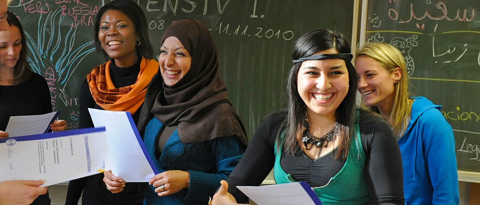 Teilnehmerinnen eines Integrationskurses "Deutsch als Fremdsprache" an der Volkshochschule Leipzig erhalten nach erfolgreichen Abschluss ihre Teilnahmebestätigungen.