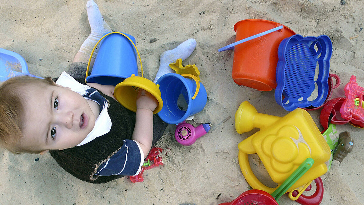 Kleiner Junge spielt im Sandkasten.