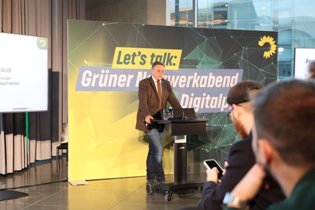 Mann auf Bühne am Redepult