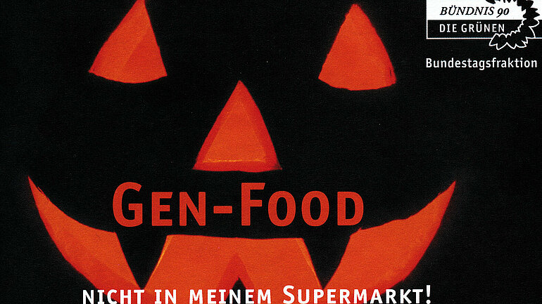 Titel: Gen-Food - Nicht in meinem Supermarkt. Das Foto zeigt ein aus einem Kürbis geschnitztes und rot-orange beleuchtetes Gesicht vor einem schwarzen Hintergrund. Es ist das Cover einer Publikation der grünen Bundestagsfraktion.