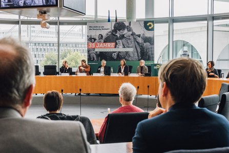 Das Bild zeigt das Podium der Veranstaltung aus der Sicht einer teilnehmenden Person.