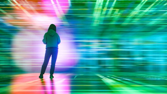 Eine Person steht in einem virtuellen Raum mit bunten Farben