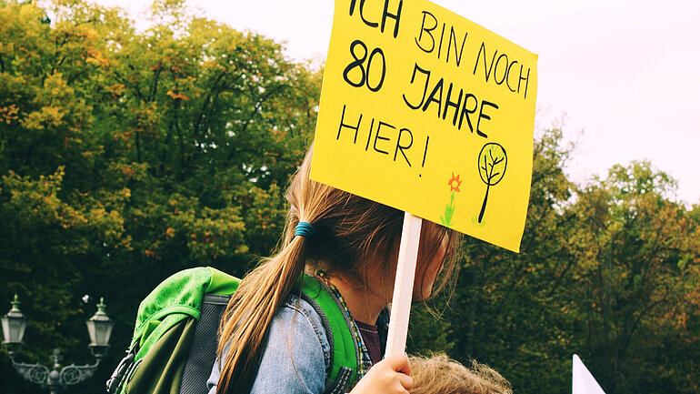 Mädchen hält Demo-Plakat hoch: "Ich bin noch 80 Jahre hier"