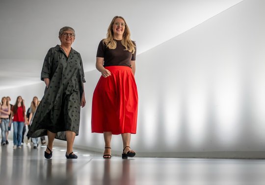 Zwei Frauen gehen nebeneinander und lächeln