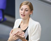 Die grüne Bundestagsabgeordnete Hanna Steinmüller am Redepult des Bundestags mit Baby in der Trage