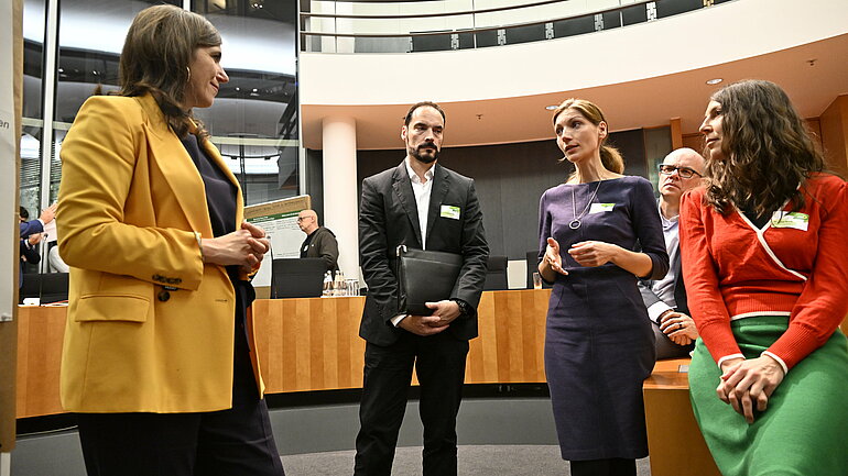 Katharina Beck MdB im Gespräch mit Teilnehmenden, unter anderem Dr. Emanuel Hensel (Mitte) sowie Dr. Antje Brock (am rechten Bildrand).