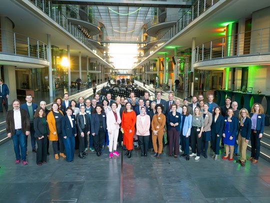 Viele Menschen stehen in einer großen Halle nebeneinander