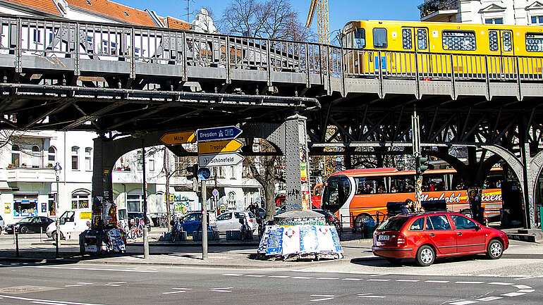 Eine Straßenkreuzung in Berlin Kreuzberg mit Autos, Ubahn und Fahrradfahrer.