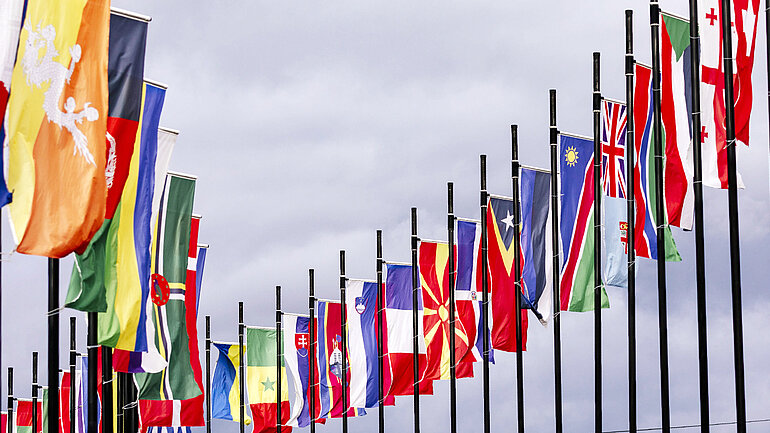 Viele internationale Flaggen wehen hintereinander.