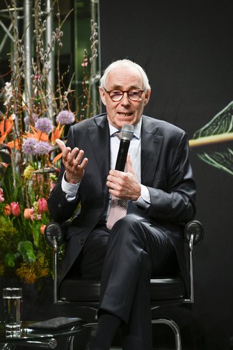 Ein Herr im Anzug spricht auf der Bühne