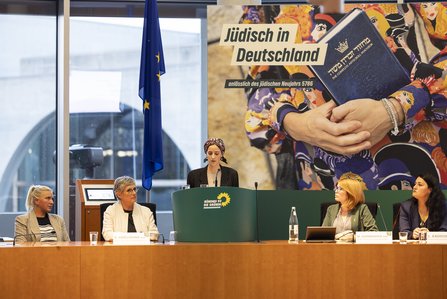 Helene Braun steht am grünen Redepult, links davon Britta Haßelmann, rechts davon die Abgeordneten Marlene Schönberger und Lamya Kaddor