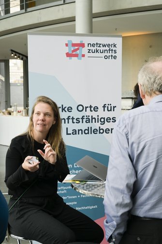 Eine Frau vor dem RollUp der Initiative "netzwerk zukunftsorte".