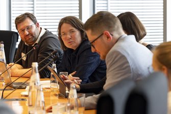 Teilnehmer sitzen während eines Workshops an einer Tischrunde.