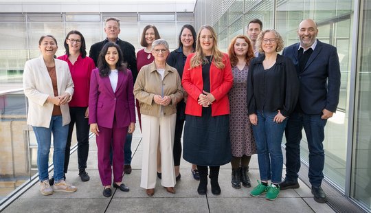 12 Personen stehen nebeneinander