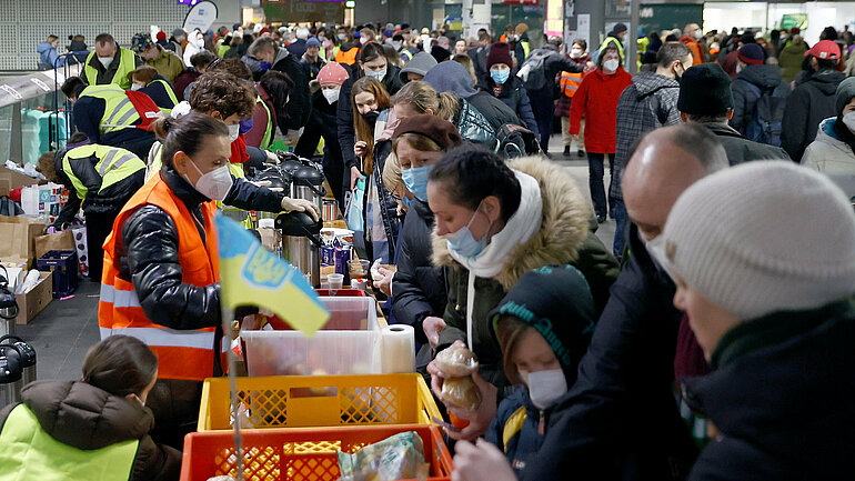 Helfer verteilen Lebensmittel an Menschen, die vor dem Krieg in der Ukraine fliehen, am Hauptbahnhof in Berlin. 