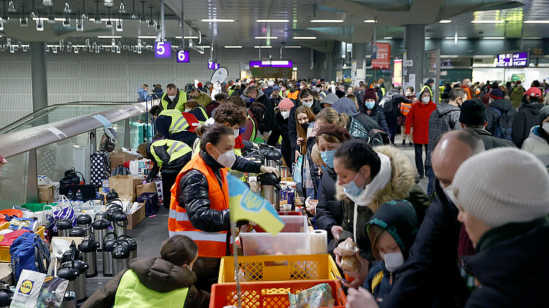 Helfer verteilen Lebensmittel an Menschen, die vor dem Krieg in der Ukraine fliehen, am Hauptbahnhof in Berlin. 