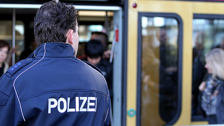 Ein Polizist steht vor einer S-Bahn