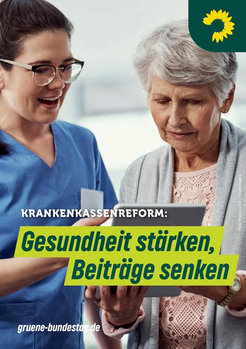 Eine junge Pflegerin im blauen Kittel schaut mit einer Seniorin auf ein Tablet