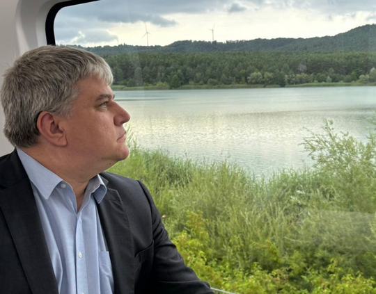 Stefan Schmidt schaut aus einem Zugfenster auf den Bezirk der Flüsse in der Oberpfalz rund um Regensburg.