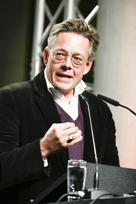 Mann spricht am Redepult