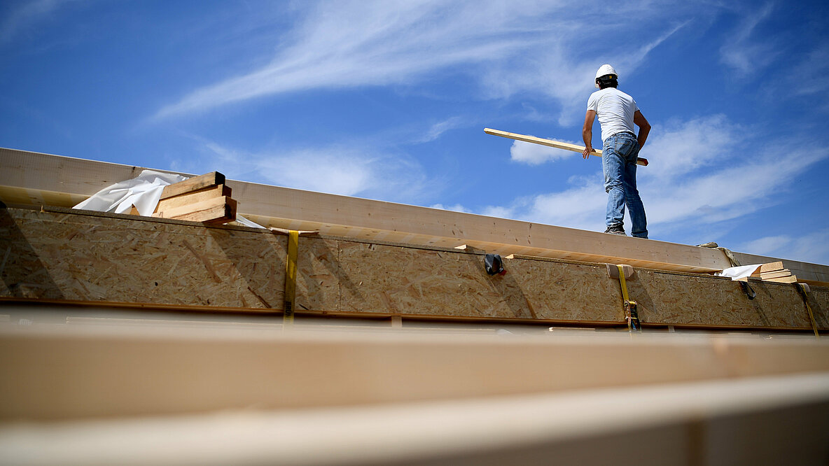 Bauarbeiter steht auf dem Dach eines Hauses